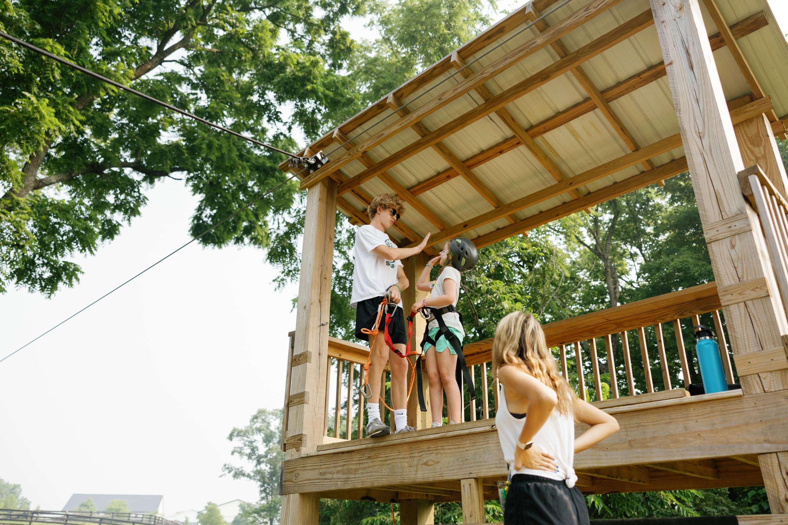 counselor explaining zipline safety to camper